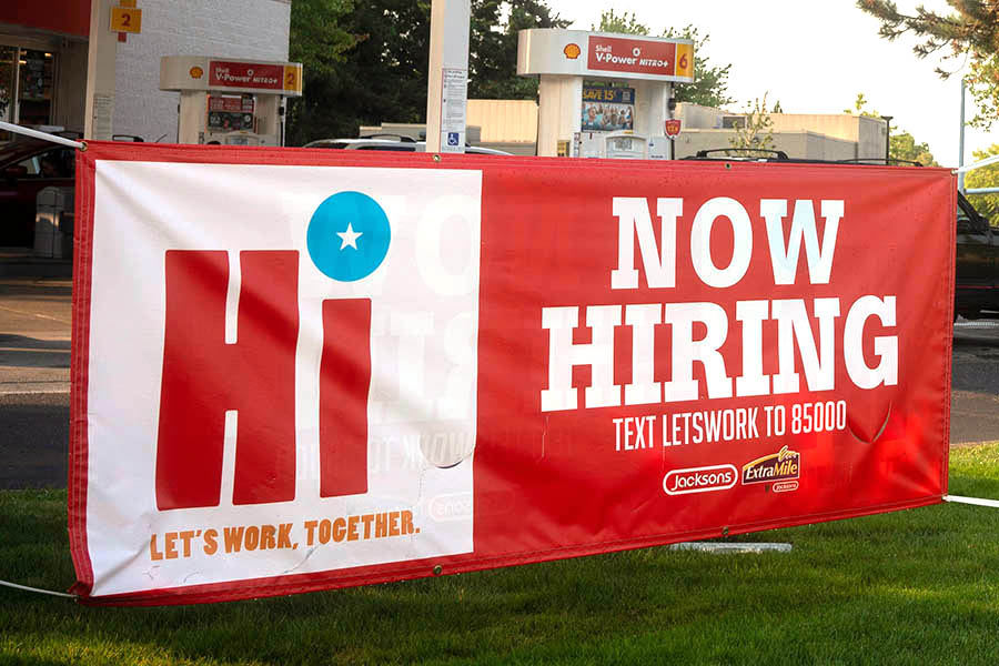 red and white banner reading "NOW HIRING"